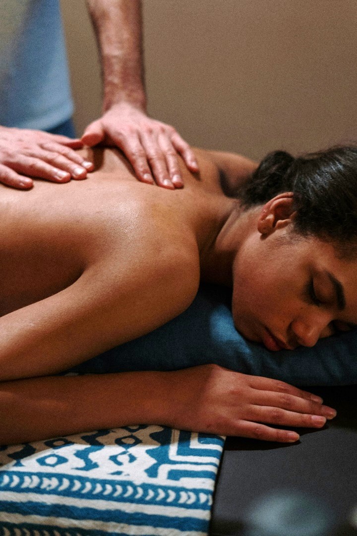   person lying down on a massage table